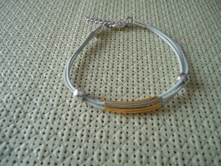 P 21-15 Pulsera cordón blanco con adornos plateados y dorados